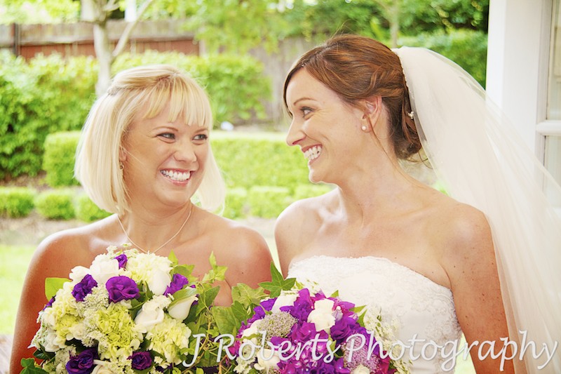 bride and bridesmaid having a laugh and fun - Wedding photography sydney